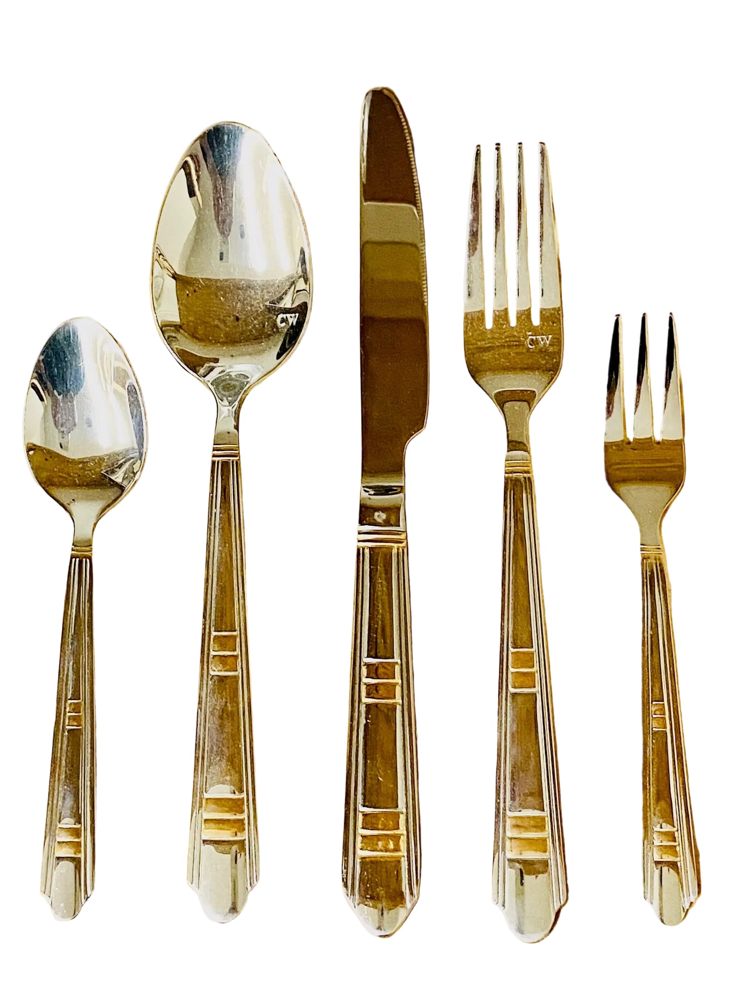 Set of silver cutlery including spoons, knife, and forks on a wooden surface