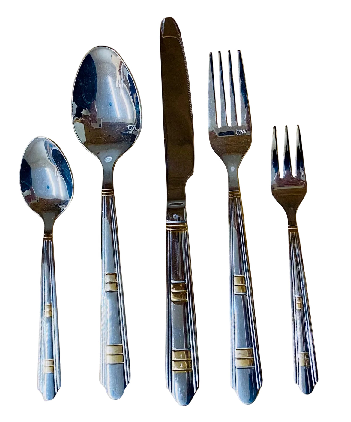 Set of silver cutlery including spoons and forks on a wooden surface